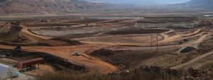A uranium tailings pile near Moab, Utah. Piles of debris lay before a vast red-soil desert.